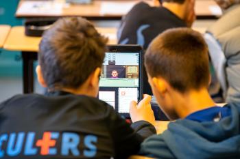 Zwei Jungen spielen im Rahmen des Projekts gemeinsam ein Spiel auf einem Tablet.